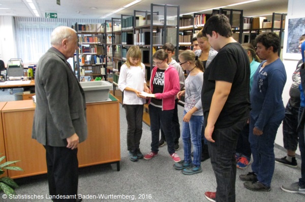 Reinhard Güll vom Statistischen Landesamt mit den Schülerinnen und Schülern der Anne-Frank-Schule Wendlingen bei der Führung durch die hauseigene Bibliothek.