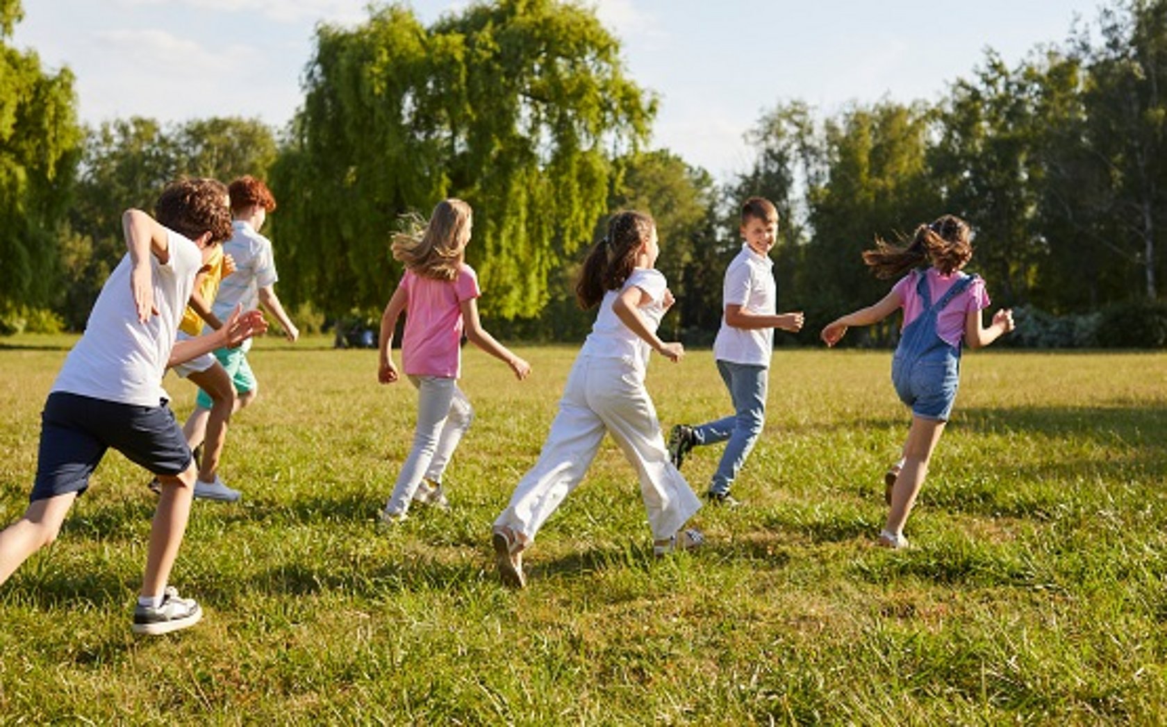 Symbolbild: 7 Kinder spielen auf der Wiese