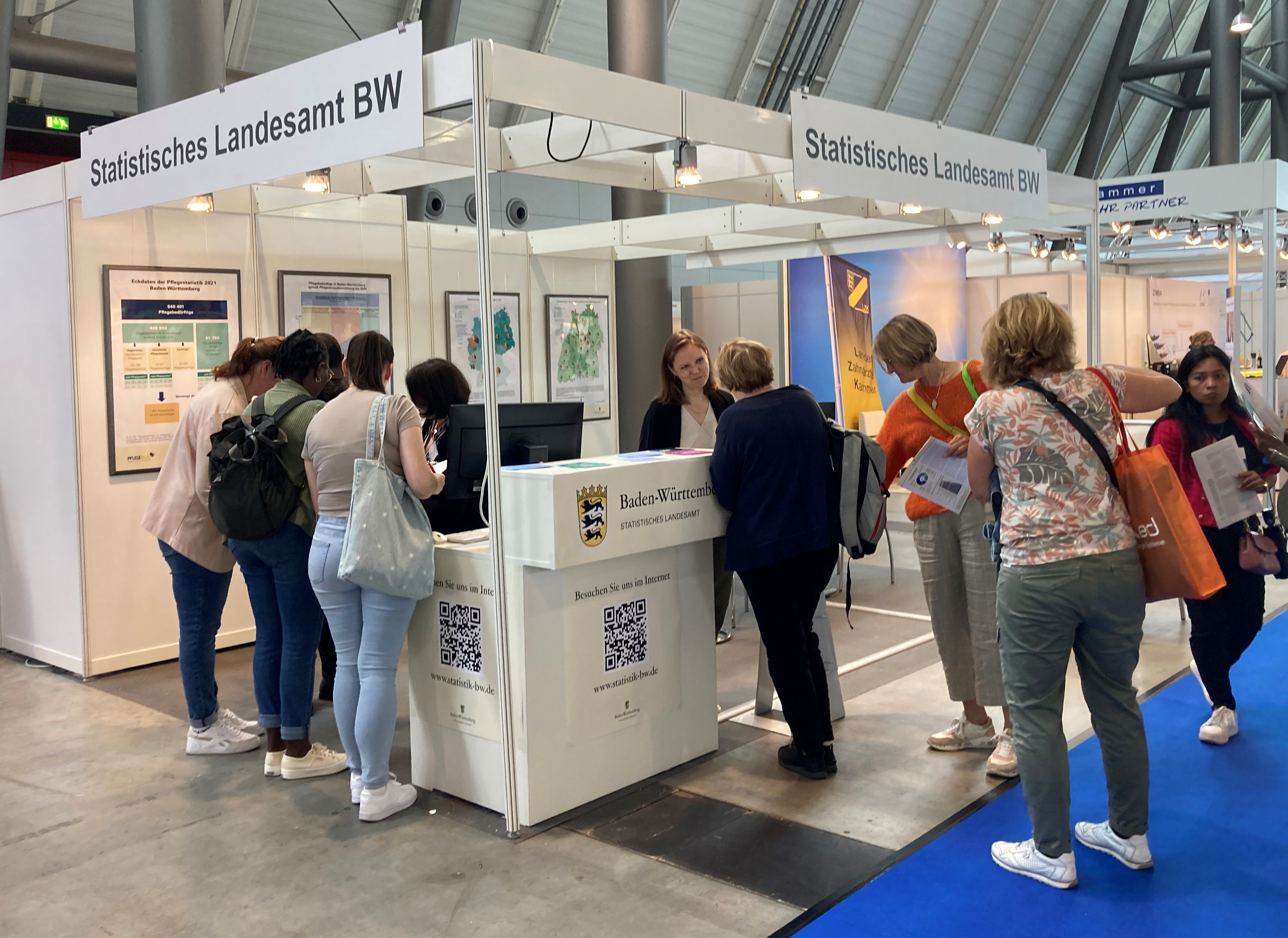 Messestand bei der Messe Pflege+ in Stuttgart 2024 Am Messestand werden Interessierte beraten.