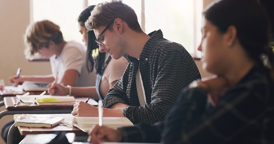 An A+ coming right up. Shot of teenagers writing an exam in a classroom. Symbolbild: Schüler im Klassenzimmer