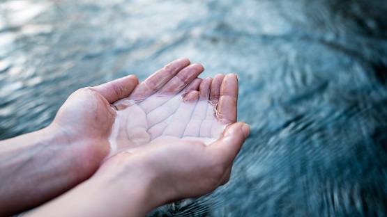 A female hand touching the river water Symbolbild: Hände mit Wasser aus Gewässer